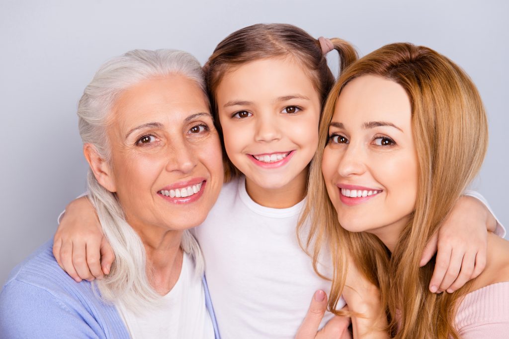 A grandmother, daughter and granddaughter smiling