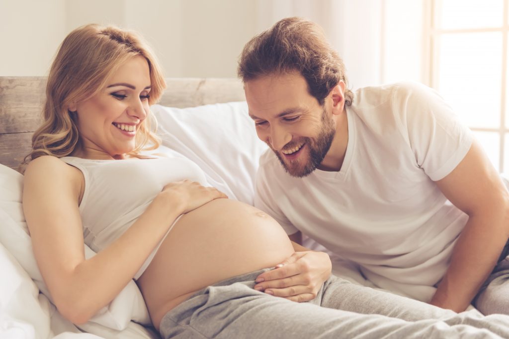 A happy couple expecting a baby, talking to the bump