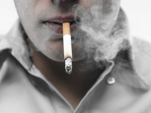 a close up view of a man smoking a cigarette