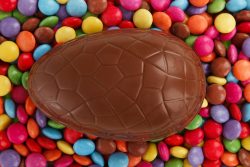 a chocolate egg lying in small coloured chocolates